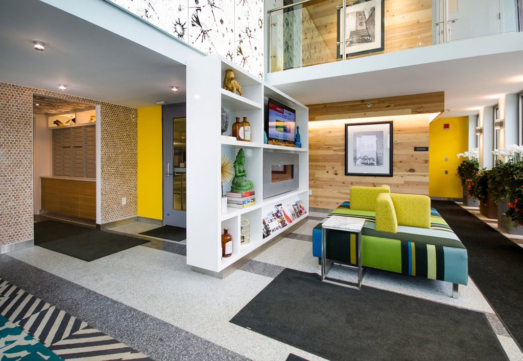 a living room with yellow walls and a green couch a living room with yellow walls and a green couch at Ann Arbor City Club, Michigan, 48104